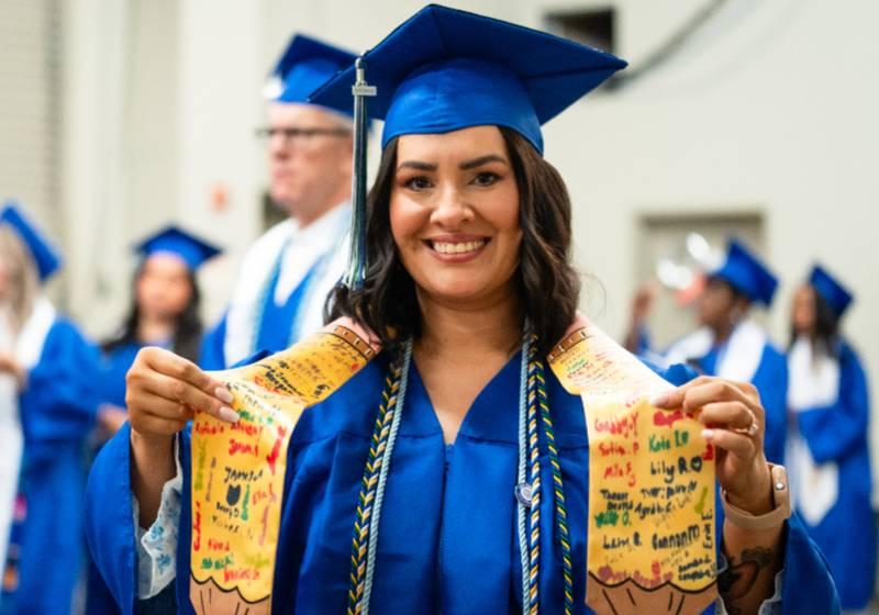 A 2025 UNT Dallas Graduate Proudly Shows Her Special Honors Stole and Cords