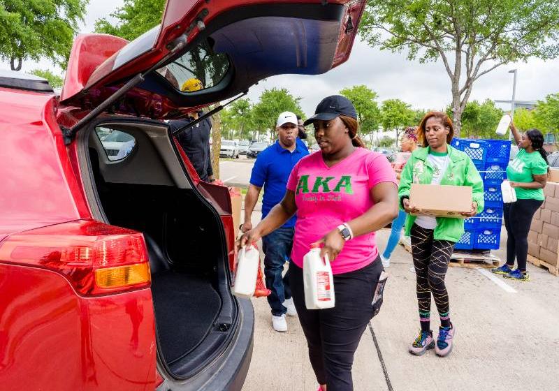 AKA Sorority Members from UNT Dallas Load Products Into an SUV at a Mobile Food Pantry Distribution