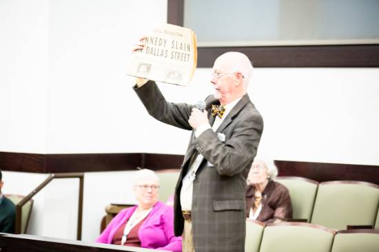 Ernie Higginbotham Holds Up The Dallas Morning News Front Page Reporting the Death of President John F. Kennedy at a College of Law Event Commemorating the 60th Anniversary of the Assassination