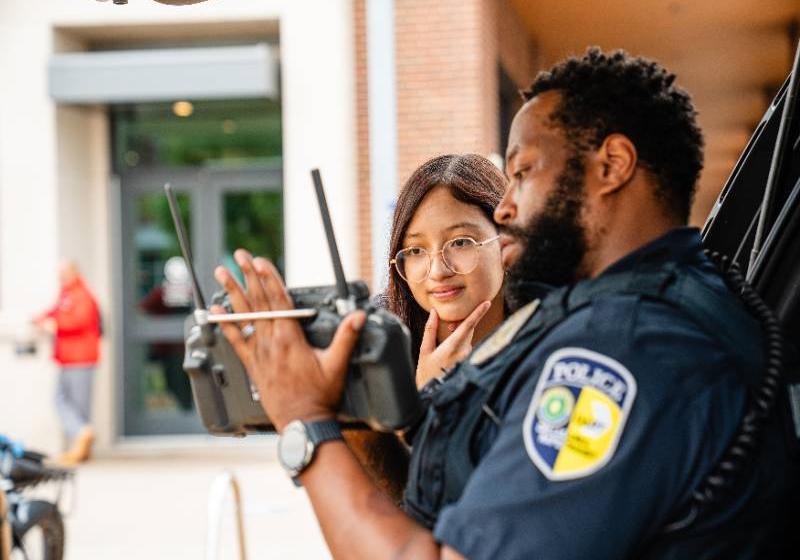 A DART Police Officer Demonstrates Electronic Equipment for a Student