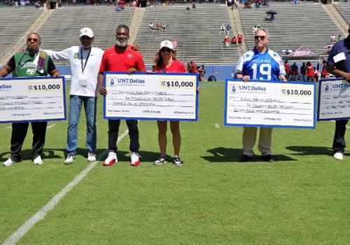 four scholarship checks, each for $10,000