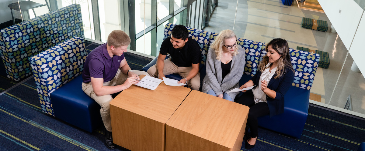 students around table in office lobby