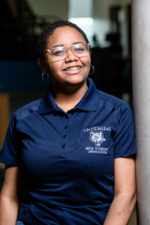 Kyra standing with a blurred background.