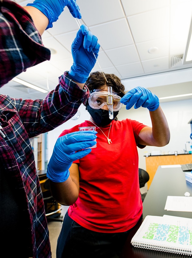 female in lab holding beaker