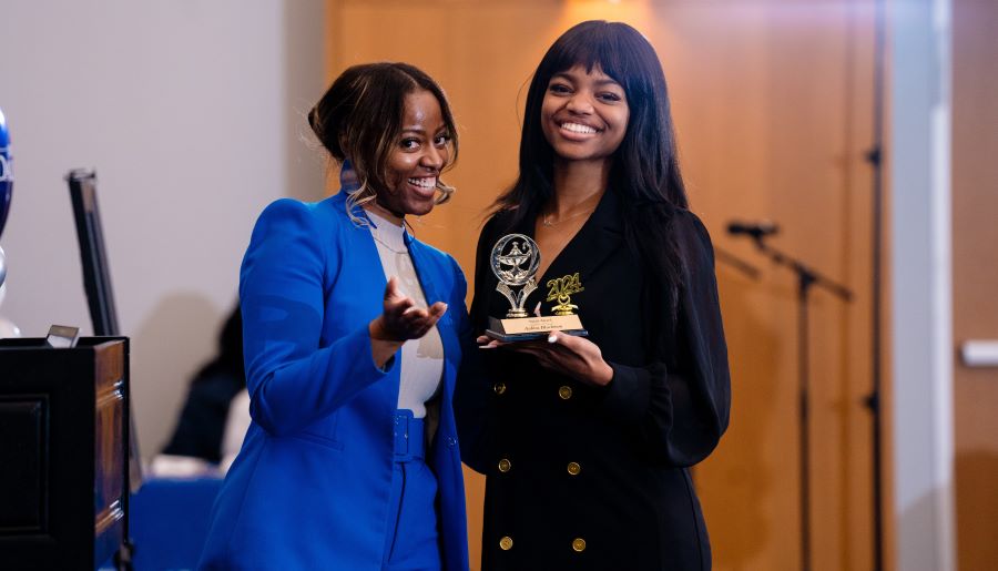 Student and faculty holding trophy