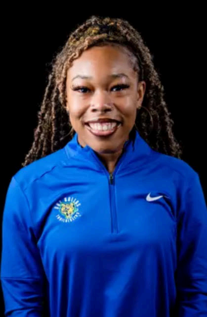 brown skin woman smiling in a blue, nike untdallad athletic pullover with goddess braids