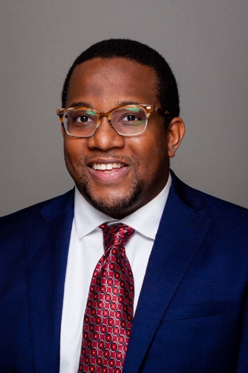 paul in a blue suit and glasses smiling