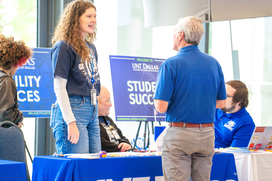 Two staff members laughing and talking