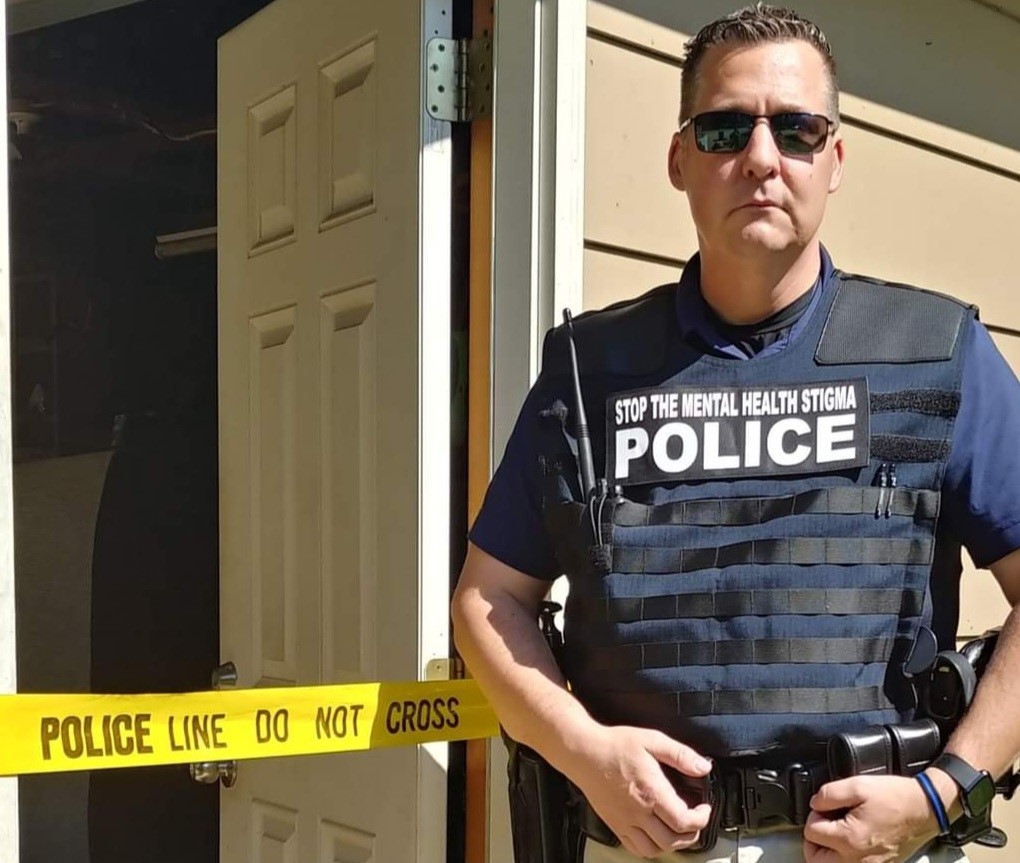 police officer posing infront of door for an article called Adam's Story